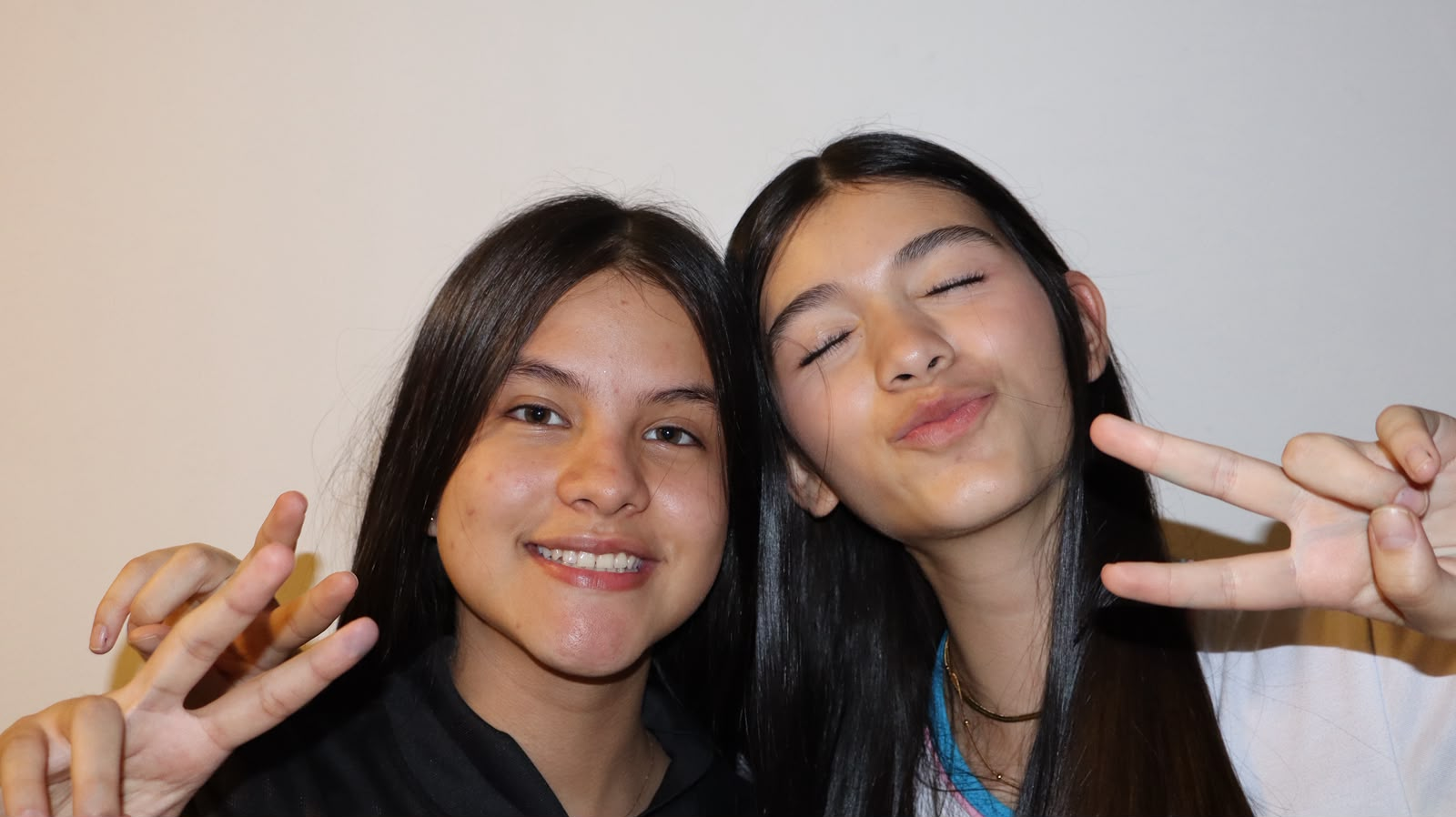 Dos amigas posando con el signo de la paz para una foto digital